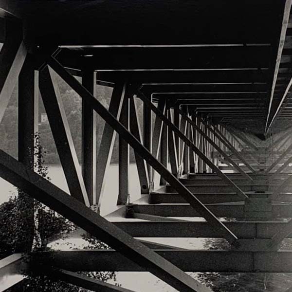 Black and white image underneath a bridge
